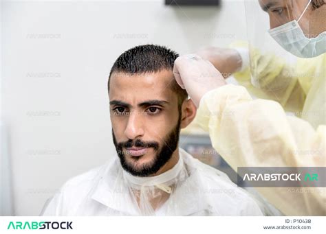 رجل سعودي خليجي في زيارة لصالون الحلاقة ، يقوم الحلاق بالعناية و الاهتمام بشعرالزبون وجعله انيقو