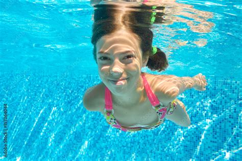 Child Swims In Pool Underwater Happy Active Girl Dives And Has Fun In