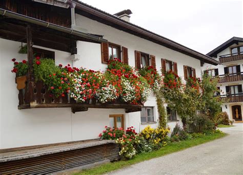 Traditional Rustic German House With Geraniums In Alpine Bavarian