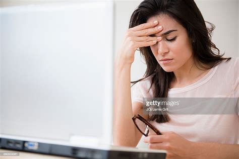 Stressed Woman Rubbing Her Forehead At Laptop Photo Getty Images