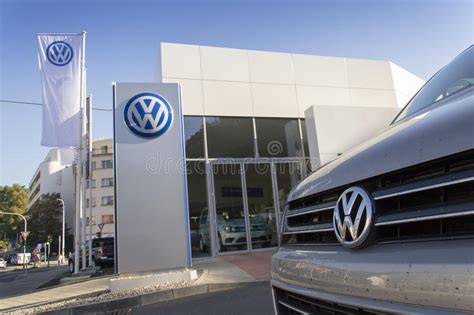 Car With Volkswagen Logo In Front Of Dealership Building Editorial