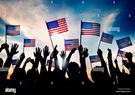 Group Of People Waving American Flags In Back Lit Stock Photo Alamy