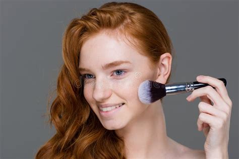 Smiling Lovely Young Female Applying Powder Blush Brush For Makeup