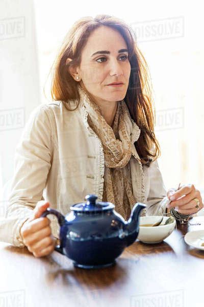 Caucasian Woman Drinking Tea At Table Stock Photo Dissolve
