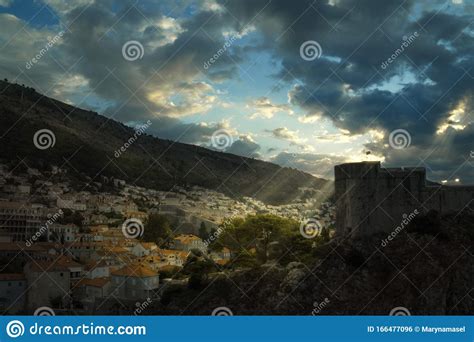 Bright Sunlight Shining Through Hole Of Clouds And Lighting Old Town