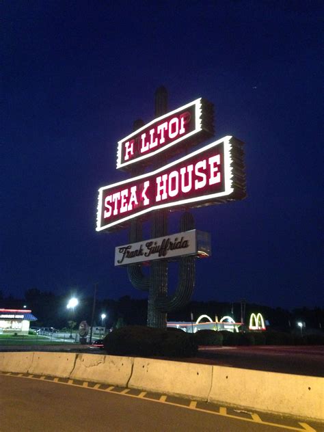 The Neon Sign For Steak And House Is Lit Up At Night With Lights On It