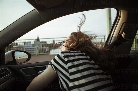 Young Woman Leaning Out Of Car Window Stock Photo