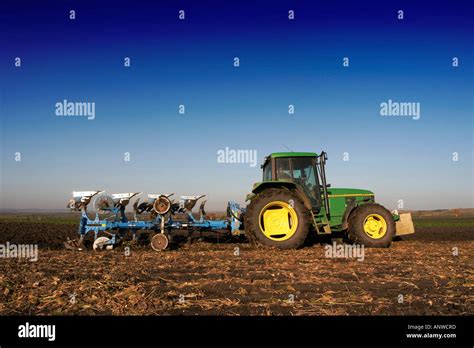 Tractor With Plough In A Field Stock Photo Alamy