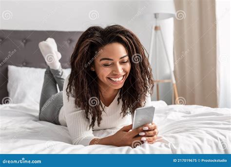 Happy Black Woman Lying In Bed Reading Text Message Stock Image Image