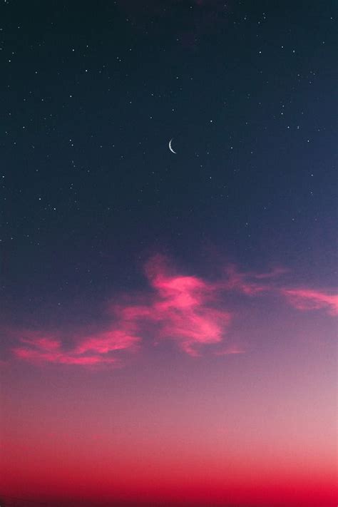 The Night Sky Is Pink And Purple With Stars Above It As Well As A Crescent