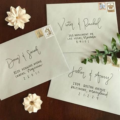 Two Envelopes With Wedding Stamps On Them And Flowers Next To Each