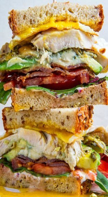 A Stack Of Sandwiches With Bacon Lettuce And Cheese On Them Sitting On