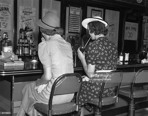 Back View Of 2 Women Both Wearing Hats 1 Wearing A Black White Print