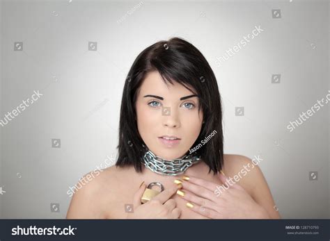 Portrait Of Sexy Woman With Chain Wrapped Around Her Neck Holding A Pad