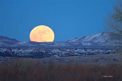 Full Moon Rising Over A Snow Dusted Desert At Bosque Del Apache