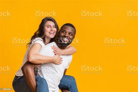 Cheerful Black Guy Piggibacking His Girlfriend Interracial Couple