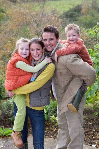 Smiling Parents Holding Children Outdoors Stock Photo Dissolve