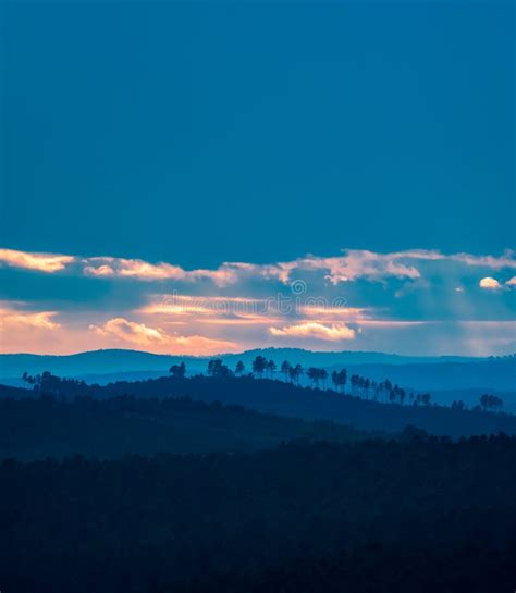 Different Layers Of Hills At Sunset With Cloudy Blue Sky Stock Photo