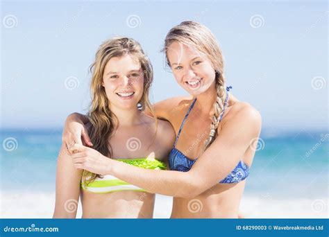 Porträt Von Zwei Glücklichen Frauen Im Bikini Der Auf Dem Strand Steht Stockbild Bild Von