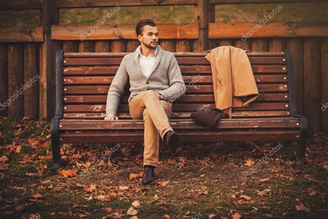 Handsome Young Man Sitting On The Bench — Stock Photo © Jozzeppe 89985980