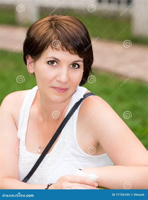 Portrait Of The Young Beautiful Smiling Woman With Flowers Outdoors