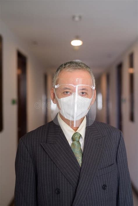 Mature Japanese Businessman Wearing Mask And Face Shield In The