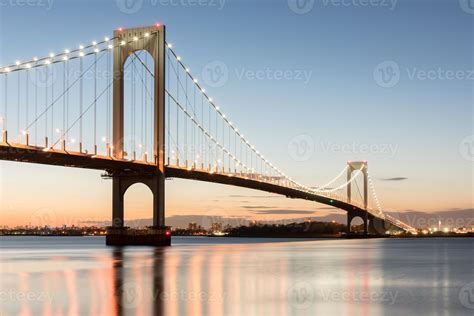 The Bronx Whitestone Bridge Reflecting On The East River At Night In