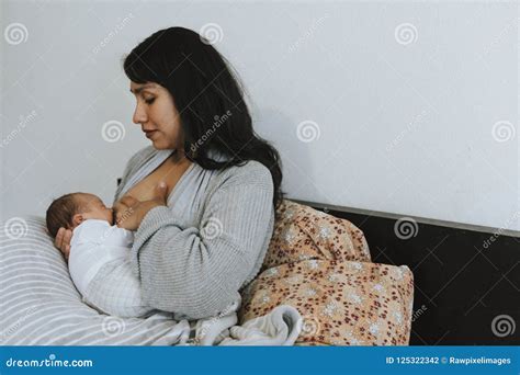 Mother Breastfeeding Her Baby On The Bed Stock Photo Image Of