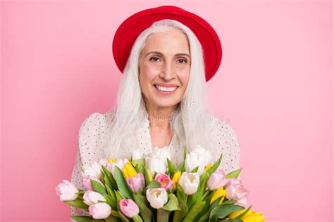 Portrait Of Attractive Cheerful Grey Haired Granny Holding Tulips