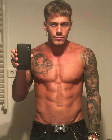 A Shirtless Man Taking A Selfie In The Mirror With His Cell Phone And Tattoos