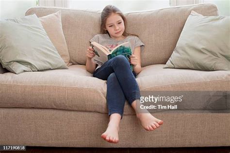 Barefoot Girl Reading Book On Couch Photos And Premium High Res