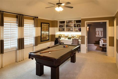 A Pool Table Is In The Middle Of A Room With Striped Walls And Carpeted