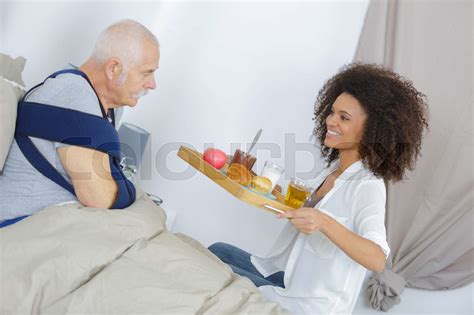 Beautiful Young Girl Is Giving Food To Handsome Old Man Stock Image
