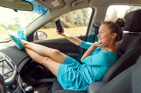 Girl In Car Sitting On Front Passenger Seat With Feet On Car Dashboard