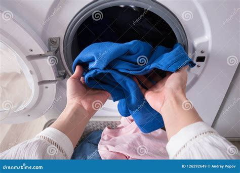Woman S Hand Putting Blue Cloth Into Washing Machine Stock Image