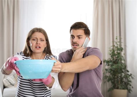 Emotional Young Woman Collecting Water Leaking From Ceiling While Her