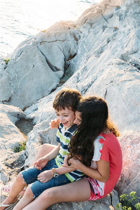 Brother And Sister Sitting On The Cliffs Having Fun Together By The