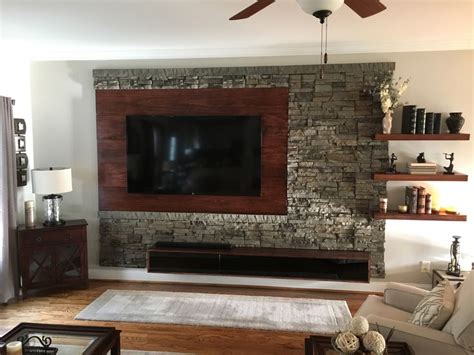 A Living Room With A Flat Screen Tv Mounted To The Side Of A Stone Wall