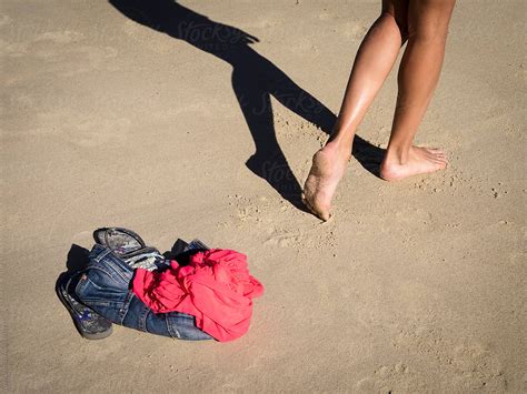 Skinny Dipping Girl Leaving Clothing On The Beach By Stocksy