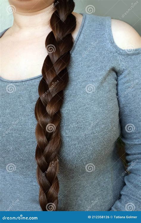 Young Woman Brunette Braids Her Long Beautiful Hair In A Thick Braid