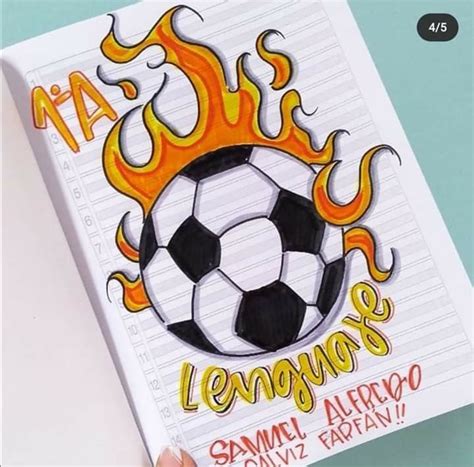 A Hand Holding Up A Book With A Soccer Ball On It And Flames Coming Out