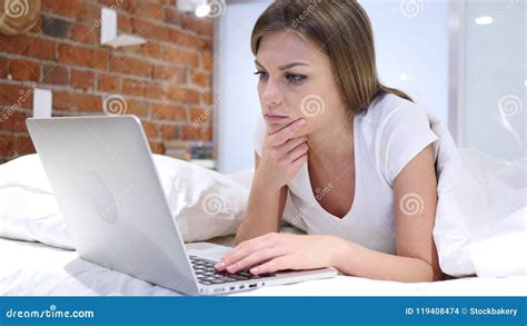 Thinking Pensive Woman Lying In Bed On Stomach Brainstorming Stock
