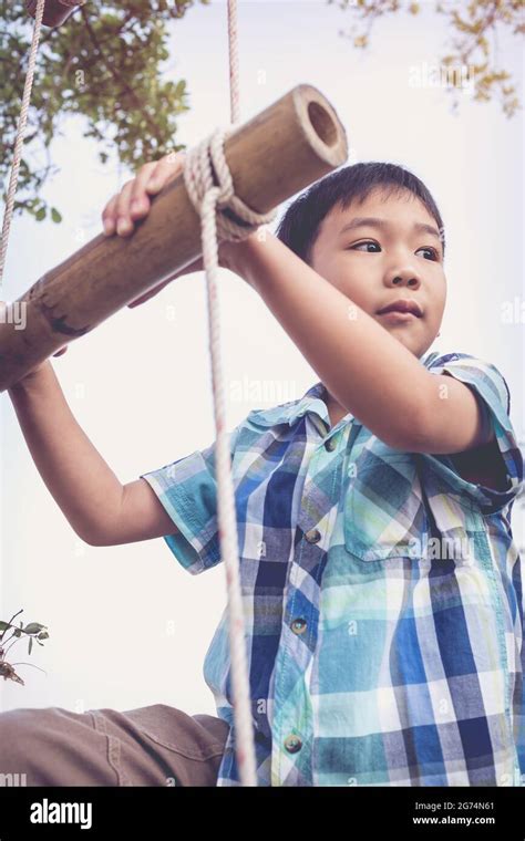 Handsome Asian Boy Climbing On Rope Ladder Made Of Wood Child Playing