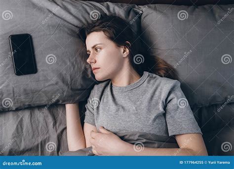 Above Top View Frightened Woman Lying In Bed Looking On Smartphone Feels Afraid And Scared