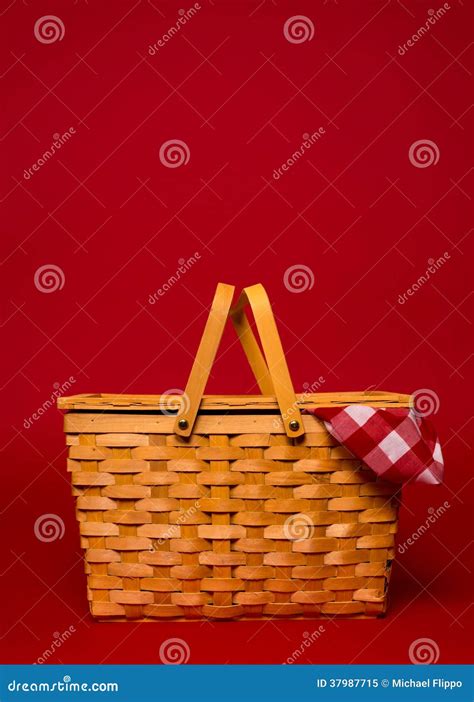 A Wicker Picnic Basket With Red Gingham Tablecloth On A Red Back Stock