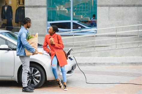 Happy Young Adult African American Man And Smiling Woman Charging