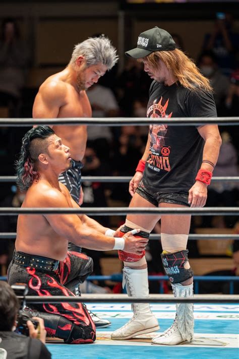 Two Men Standing Next To Each Other In A Wrestling Ring