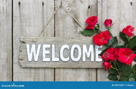 Rustic Welcome Sign With Red Flowers Hanging On Wood Door Stock Image
