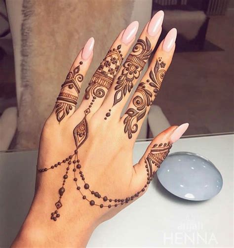 a woman s hand with henna tattoos on it