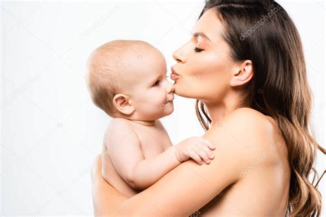 retrato de madre desnuda atractiva abrazando y besando bebé niño